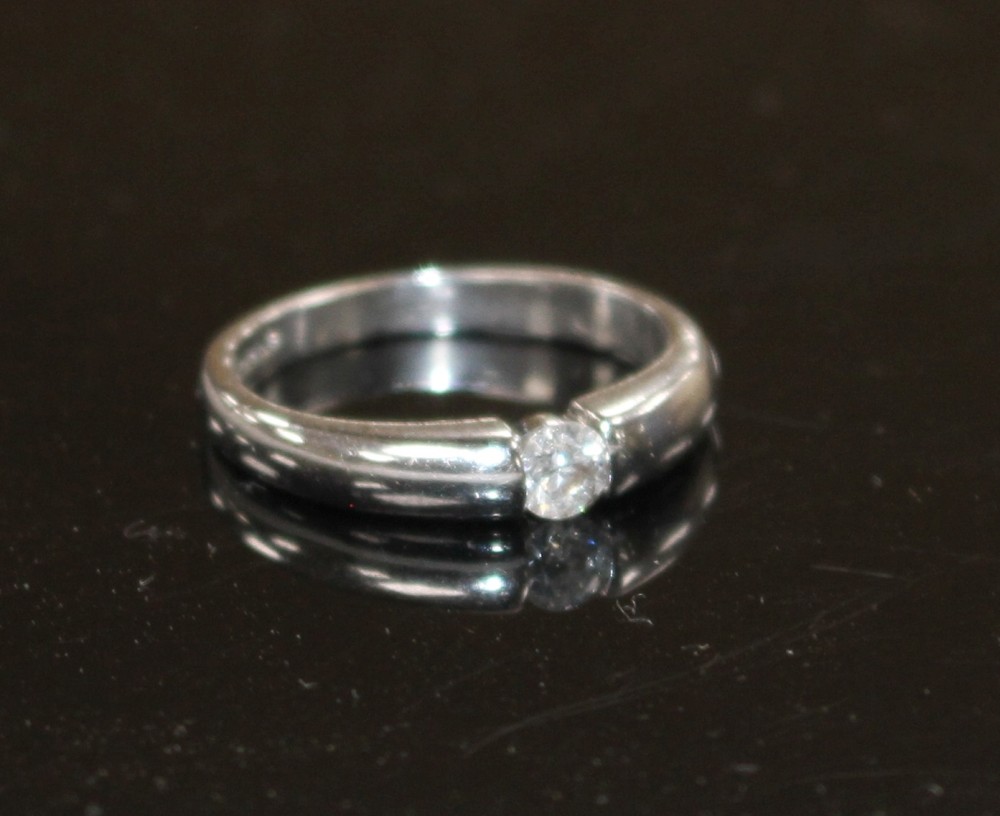 A modern 18ct white gold channel set solitaire diamond ring, size L, gross weight 3.6 grams.
